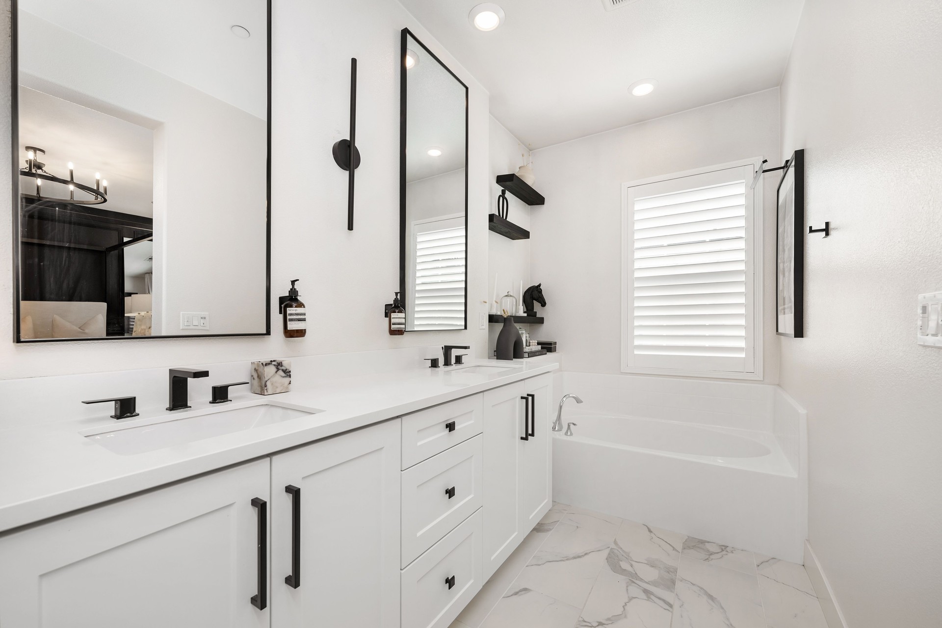 Modern bathroom with white cabinets and black fixtures.